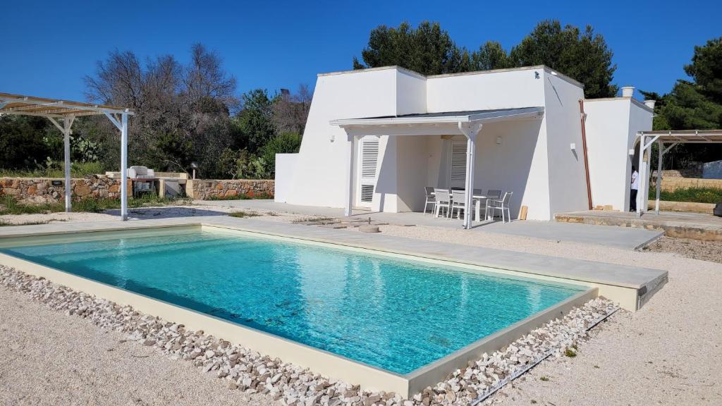 una villa con piscina di fronte a una casa di Villa Pescoluse a Marina di Pescoluse