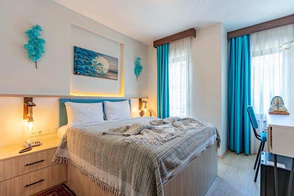 1 dormitorio con 1 cama, escritorio y ventanas en Stanpoli Hostel, en Estambul