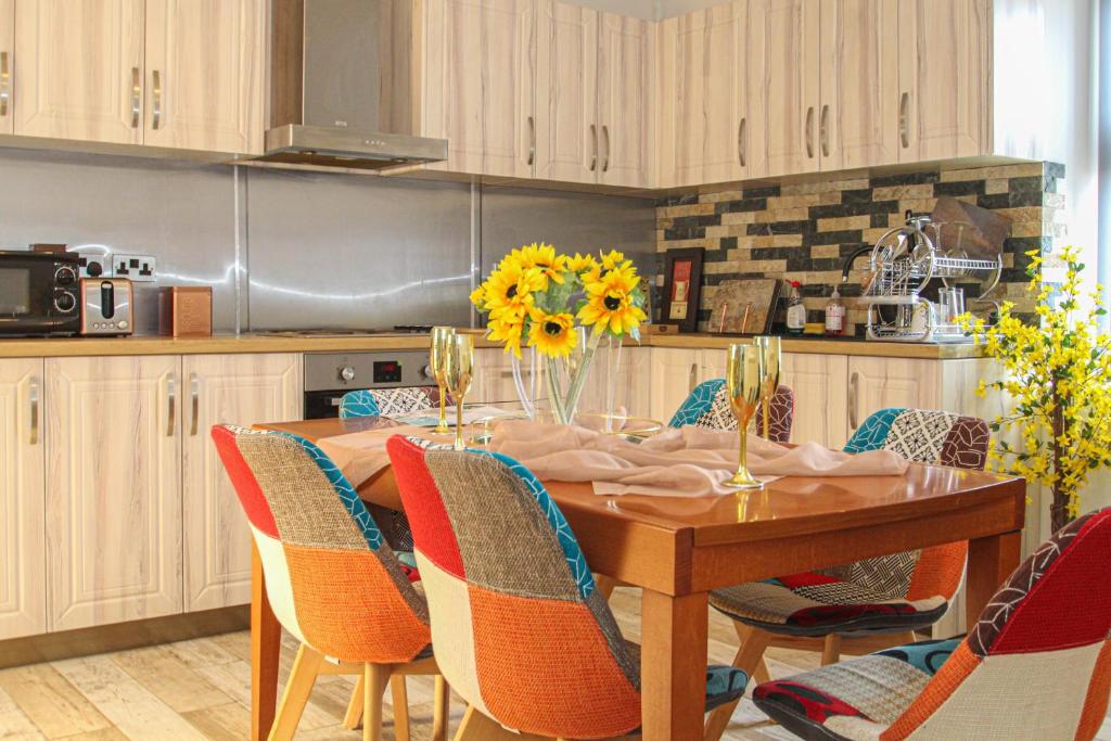 een keuken met een houten tafel met stoelen eromheen bij Deluxe Apartment in Lanark