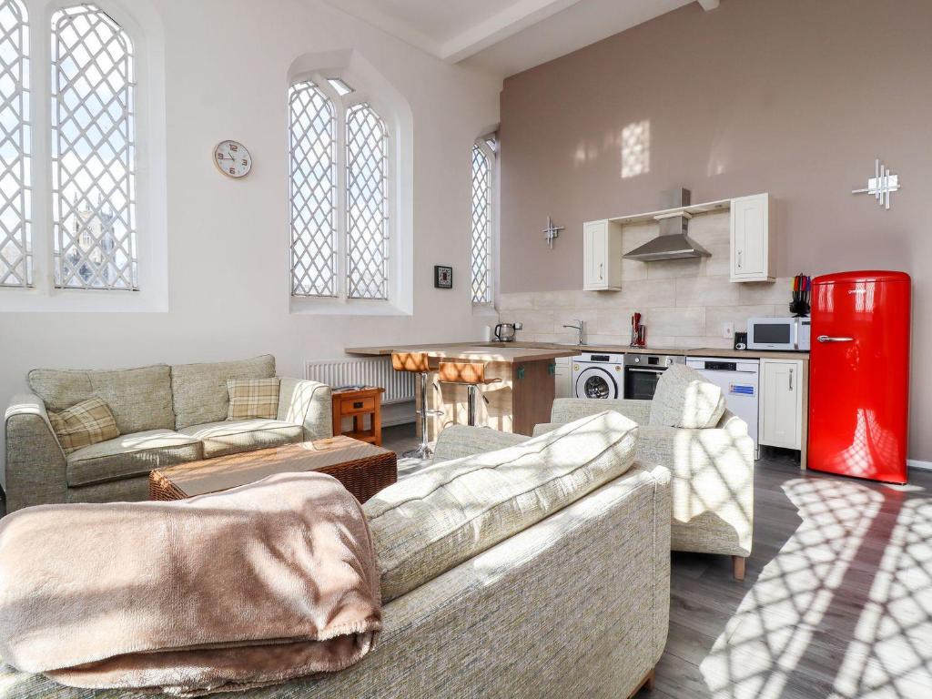 a living room with two couches and a kitchen at Asquith Penthouse in Huddersfield