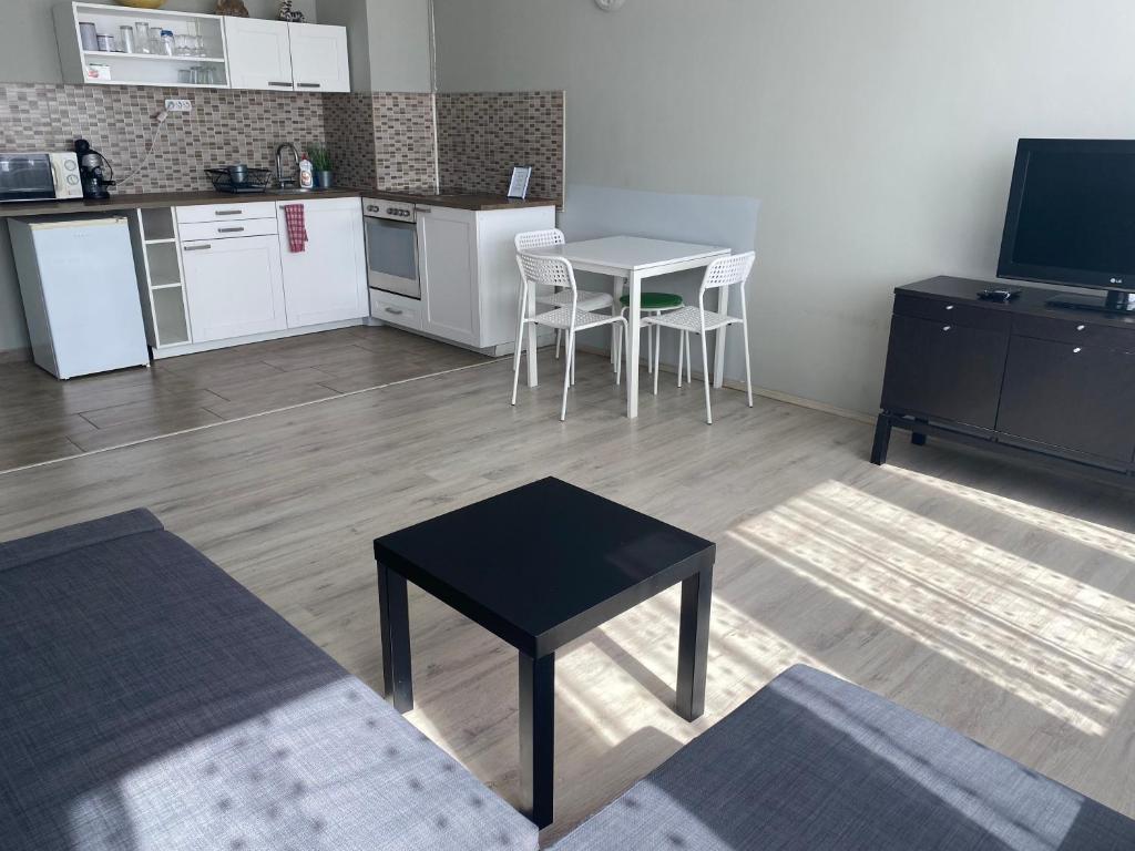 a living room with a table and a kitchen at Dózsa Apartman in Gödöllő