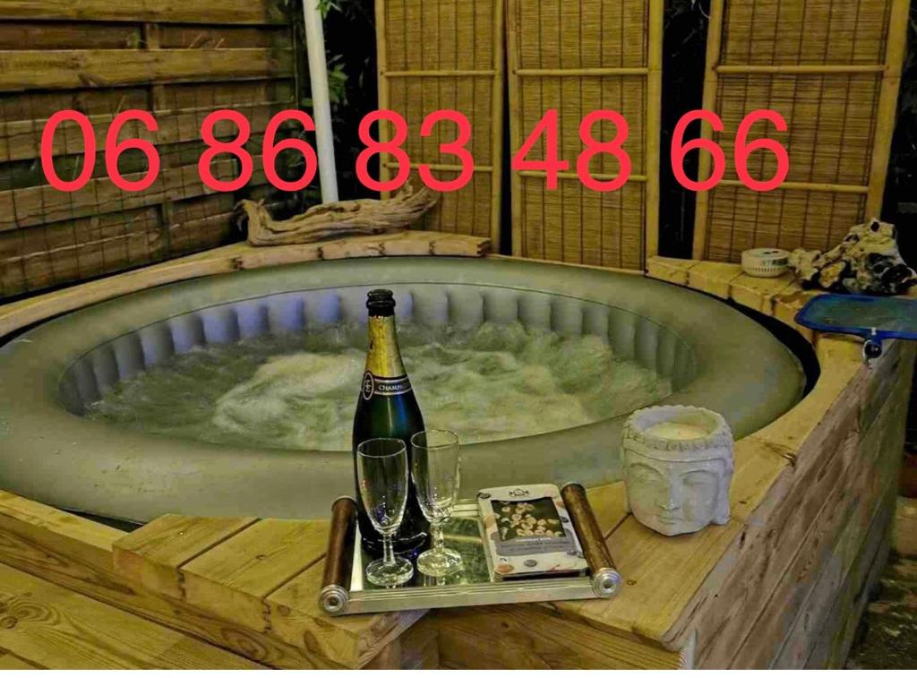 - Botella de champán en la bañera con copa en Chez Vincent et Myriam gîte de charme, en Aussonne