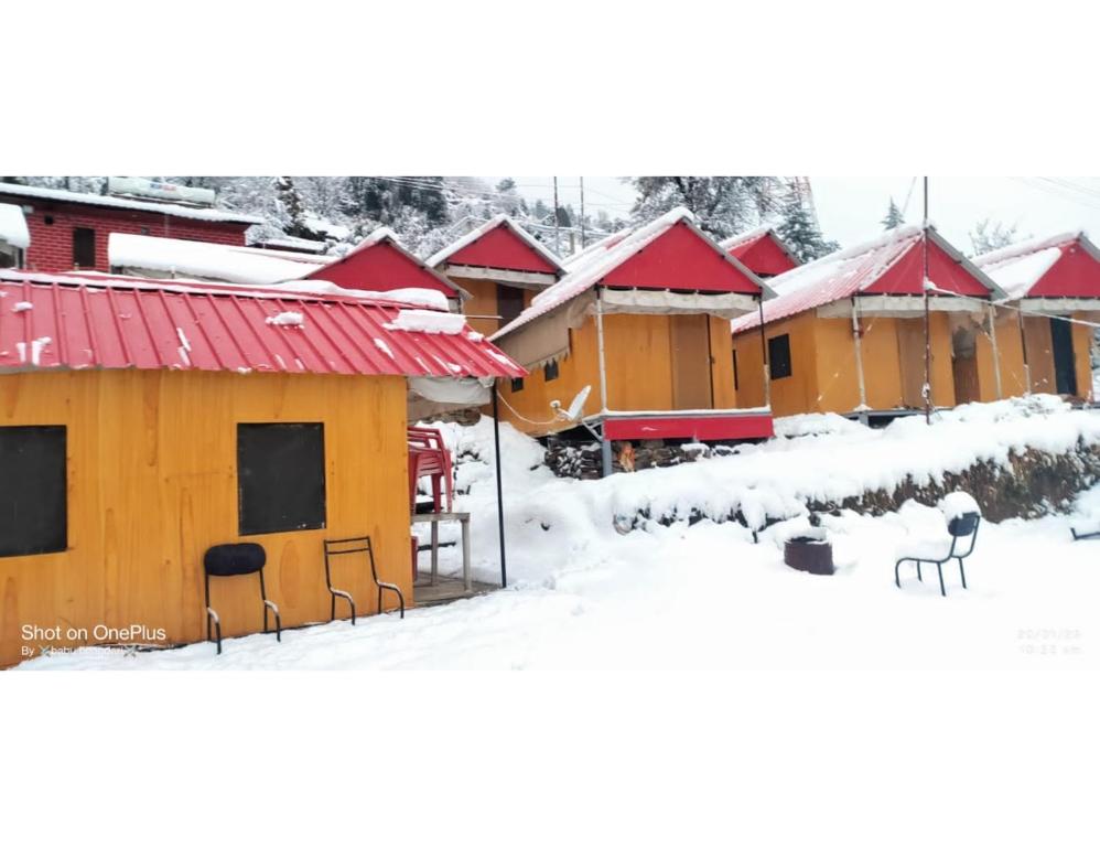 rząd domów w śniegu w obiekcie Shivalik Camping & Cottage, Joshimath w mieście Jyotirmath