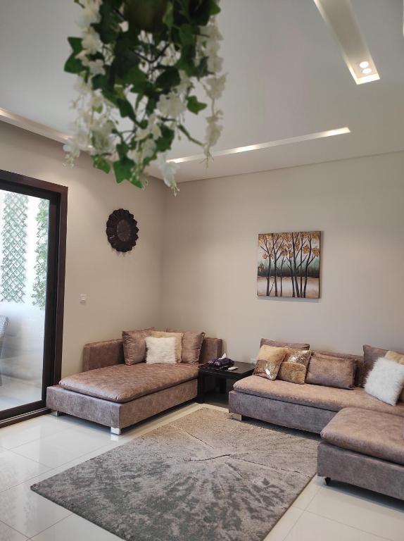 塞拉萊的住宿－Segal Salalah-Forest Island-Hawana，客厅配有两张沙发和一个吊灯。