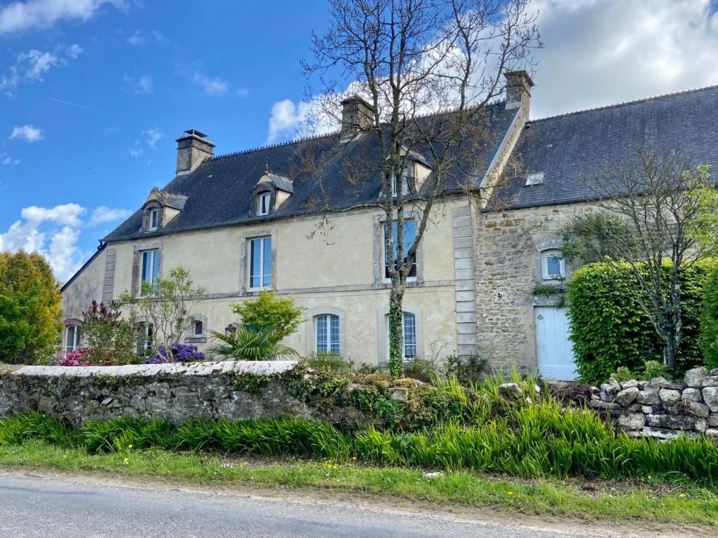 una antigua casa de piedra con una pared de piedra en La Ptite Normande en Saint-Germain-de-Tournebut