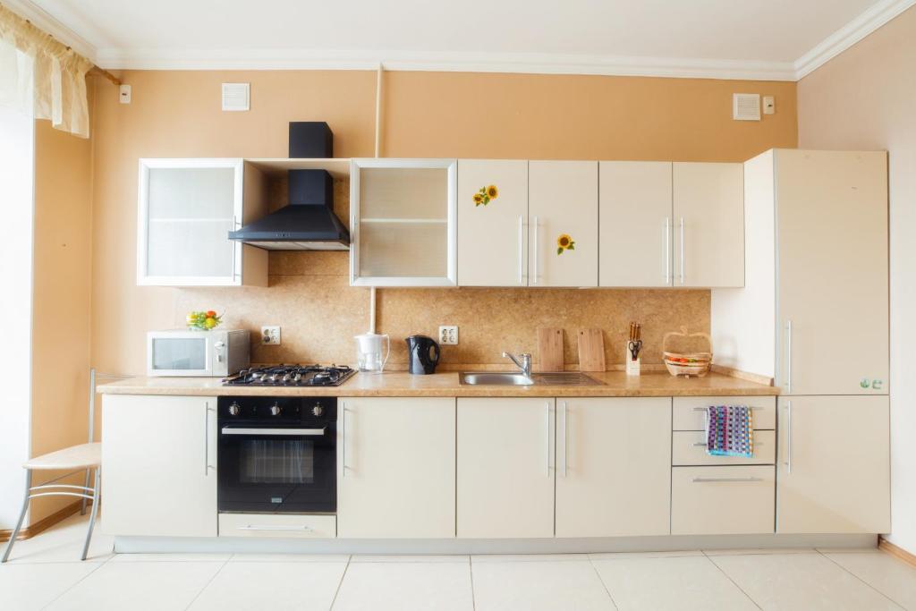 車里雅賓斯克的住宿－Five Stars with 2 bedrooms，厨房配有白色橱柜和炉灶烤箱。