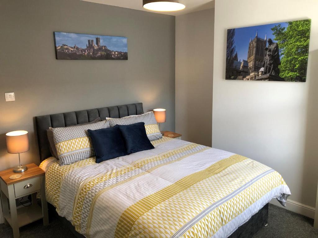 a bedroom with a bed and two pictures on the wall at Hattie's Cottage in Lincoln