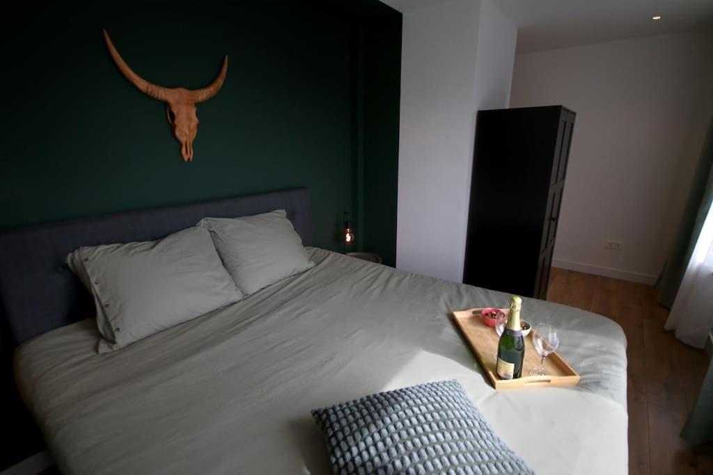a bedroom with a bed with a deer skull on the wall at Het Pareltje van Walsoorden in Walsoorden