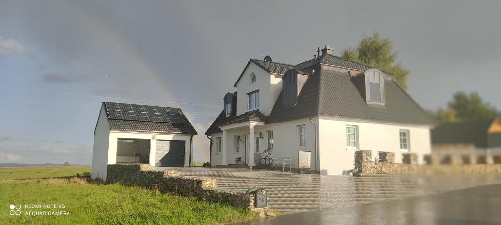 a white house with solar panels on the roof at Ferienwohnung Firmenmietwohnung Jurastein in Deining