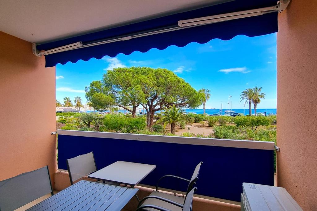 a balcony with a table and chairs and a view of the ocean at Apartment in Fréjus Plage by the seaside with direct access to the beach in Fréjus