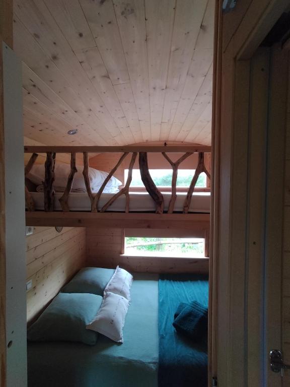 Łóżko lub łóżka w pokoju w obiekcie La roulotte de Jane
