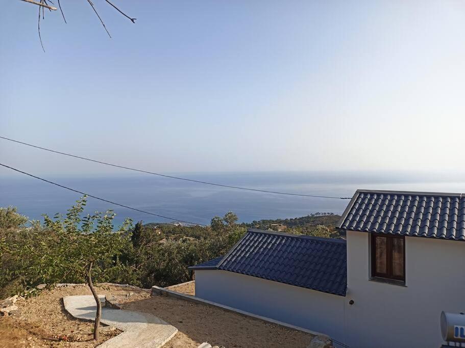 a white house with a view of the ocean at Aloni Cottage above Aegean Sea in Raches