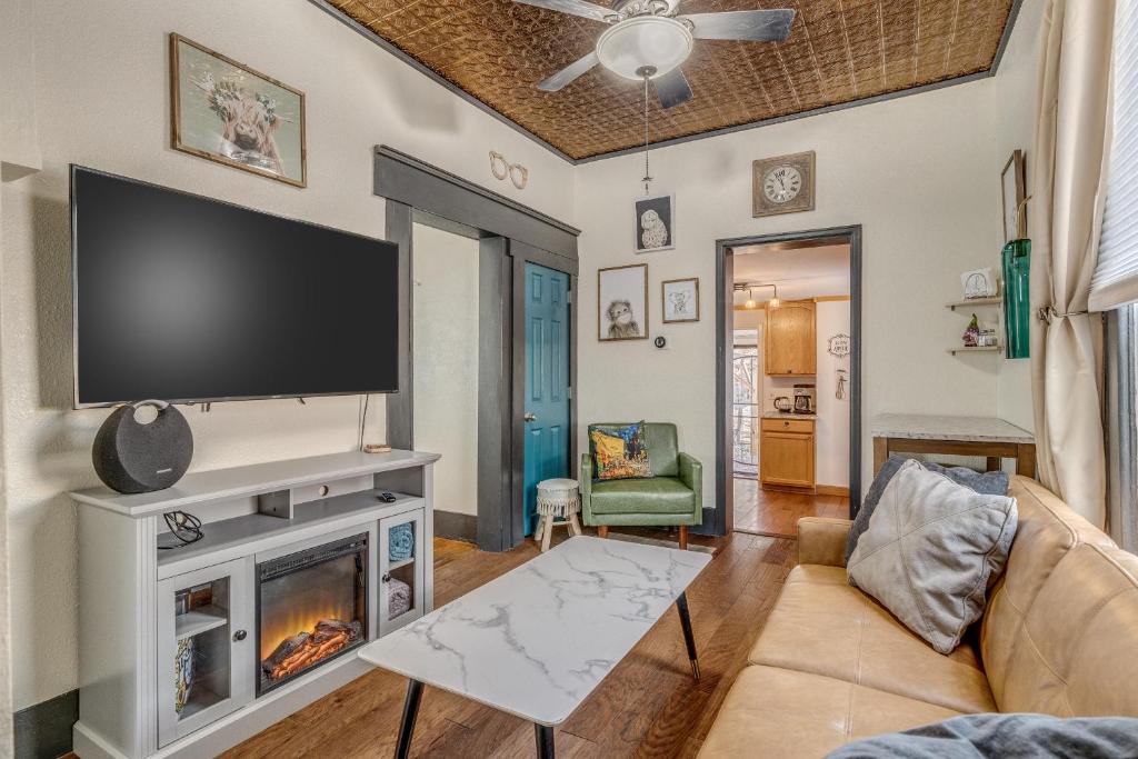 a living room with a fireplace and a flat screen tv at Downtown Colorado Springs House in Colorado Springs