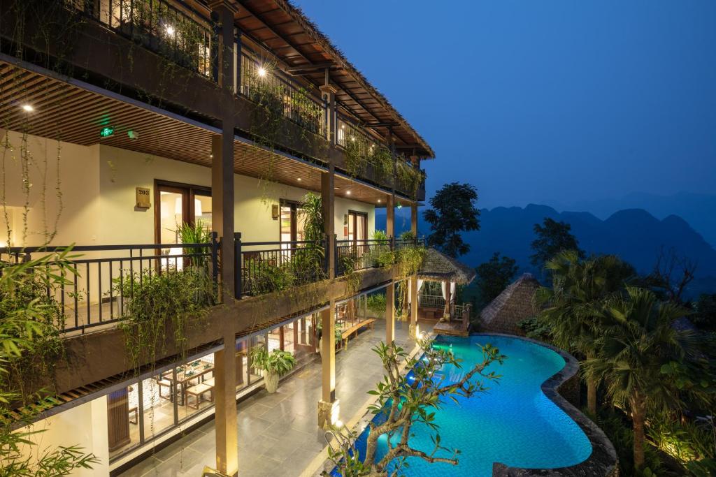 una imagen de un hotel con piscina por la noche en EBINO PULUONG RESORT en Pu Luong