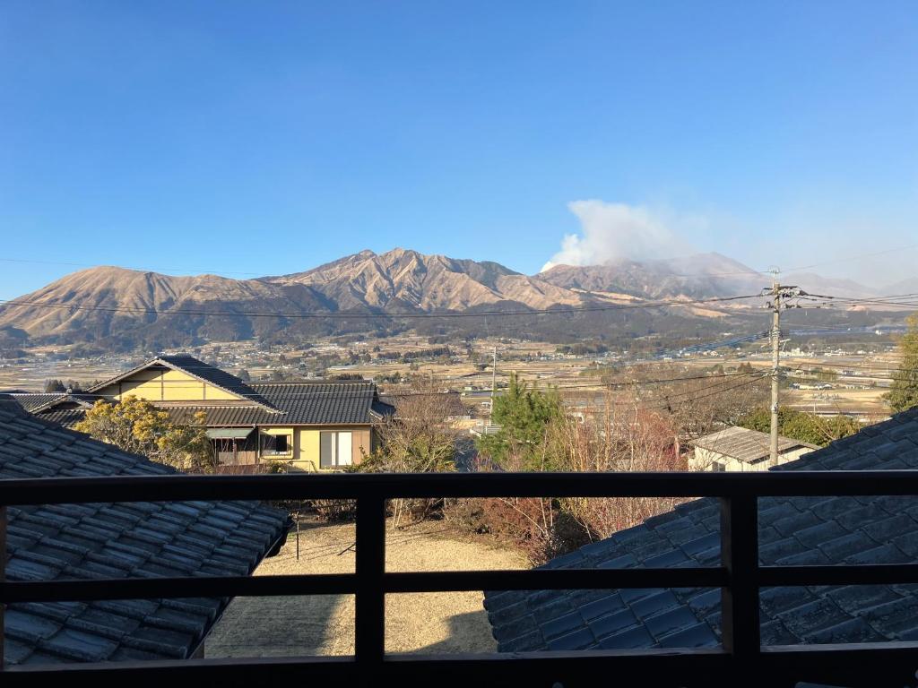 a view of the mountains from the roof of a house at お宿でん吉 in Minami Aso