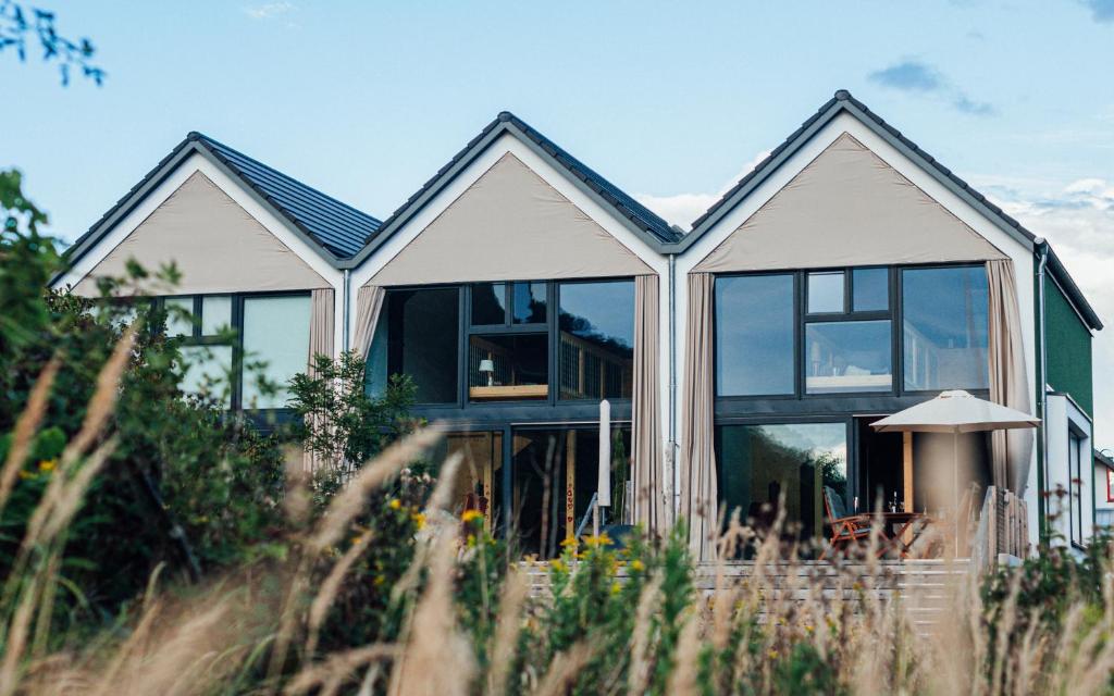ein Haus mit großen Fenstern an der Seite in der Unterkunft Premium Design Ferienhäuser Mosel Chalets in Pommern