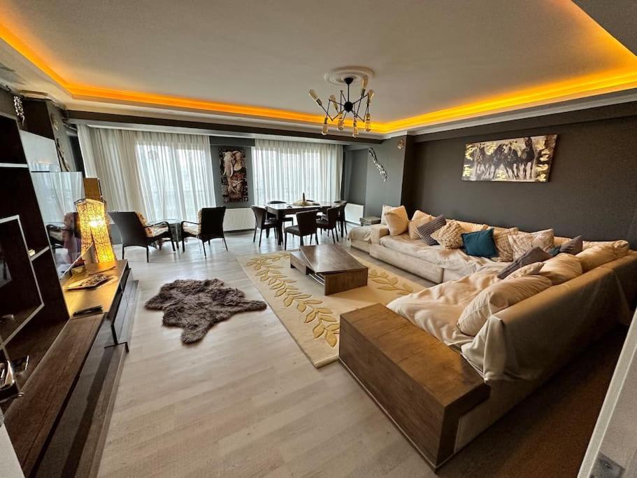 een woonkamer met een grote bank en een eetkamer bij Akhome - Luxury dublex apartment in Canakkale