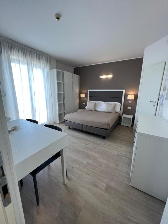 a bedroom with a bed and a table in a room at Hotel Ardea in Riccione