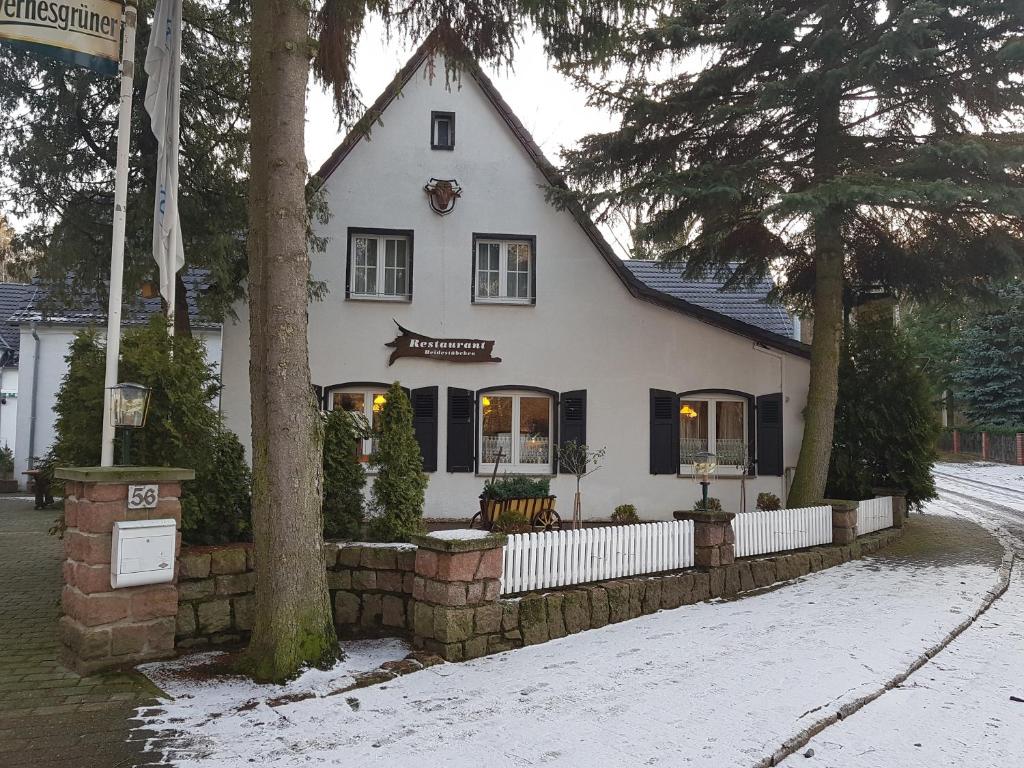 una casa blanca con una cerca en la nieve en Hotel Landgut Ochsenkopf en Rotta