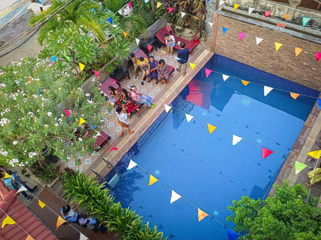 an overhead view of a swimming pool with flags and people at Jasmine Lodge Siem Reap in Siem Reap