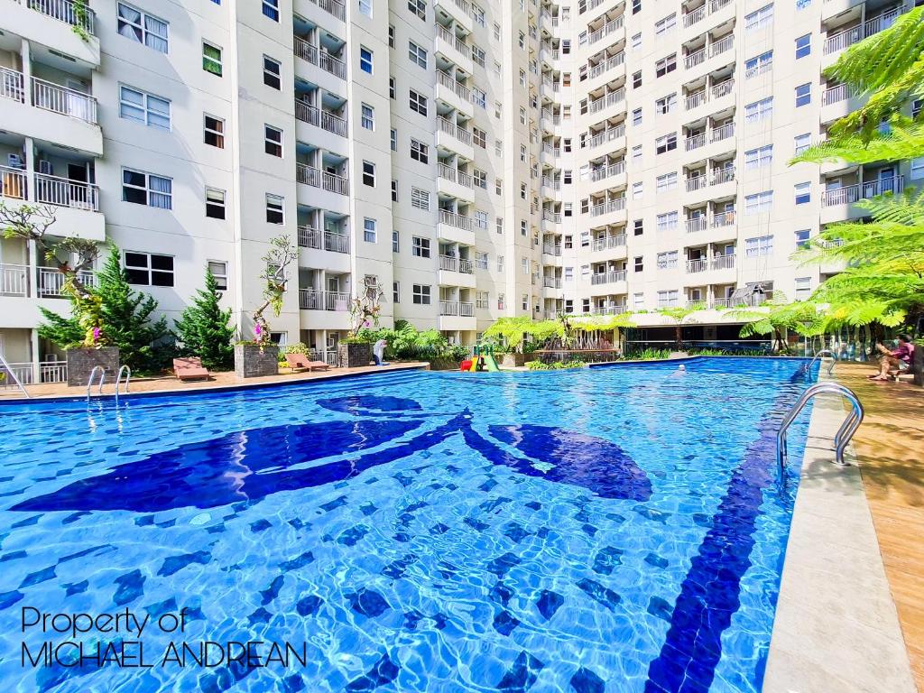 een groot zwembad voor een gebouw bij Parahyangan Residences by AYA Stays in Bandung