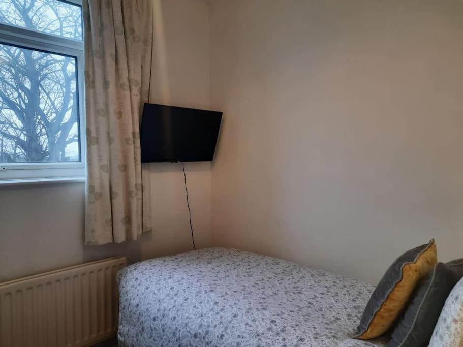 a bedroom with a bed and a tv on the wall at Private rooms with breakfast in Bishop Auckland in Bishop Auckland