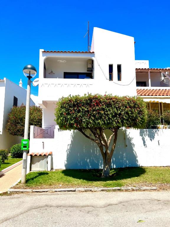 a white building with a tree in front of it at CasAzul in Olhão