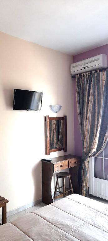 una camera con letto, scrivania e finestra di Stefanosplace ApartHotel Sea View a Barbati
