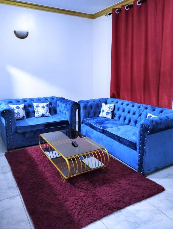 salon z niebieską kanapą i stołem w obiekcie Bamburi Luxury Homes 2 w mieście Bamburi