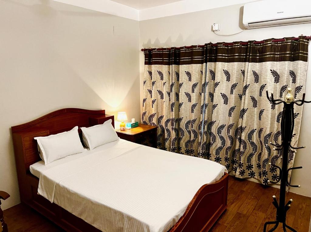 婆羅多布爾的住宿－Paris Guest House，一间卧室配有床和窗帘