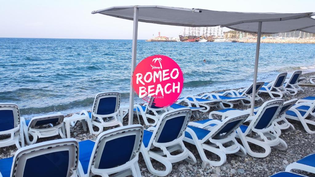 فندق روميو بيتش في كيمير: مجموعة من الكراسي ومظلة على الشاطئ