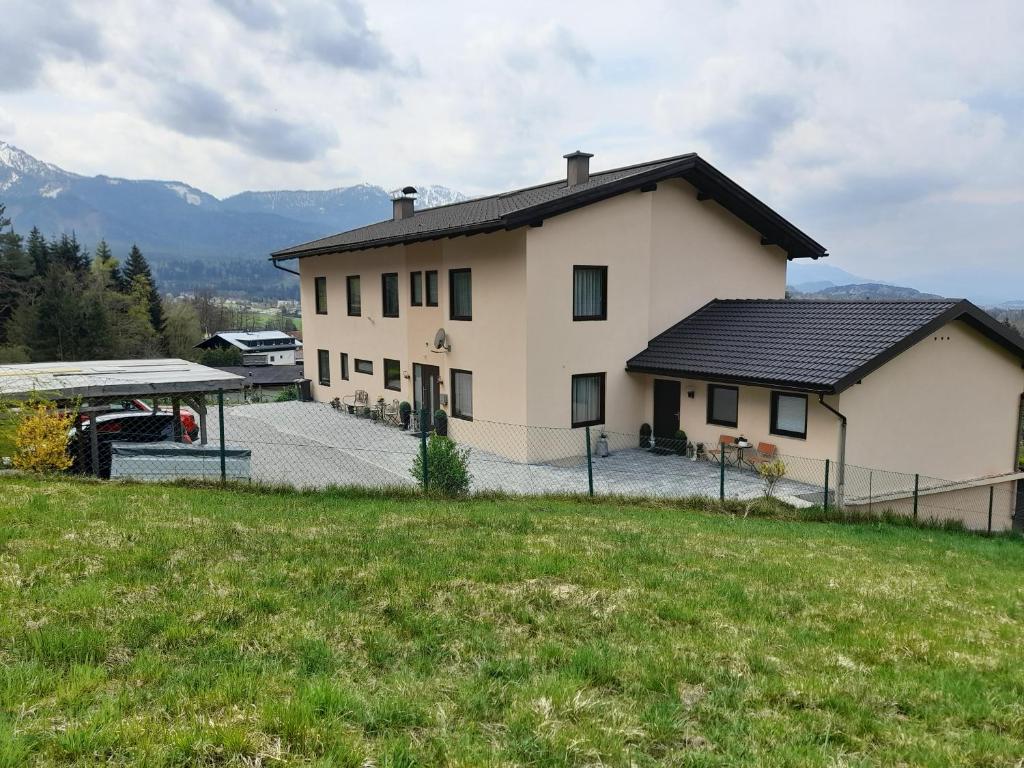 ein Haus auf einem Hügel mit einem grünen Feld in der Unterkunft Gästehaus am Walde - Familie Troller in Ledenitzen