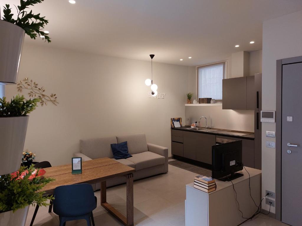 a living room with a table and a kitchen at the 6 apartments in Rimini