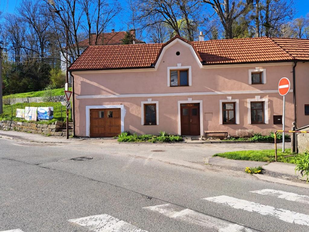una pequeña casa rosa en la esquina de una calle en Vila Hedvika en Nové Hrady