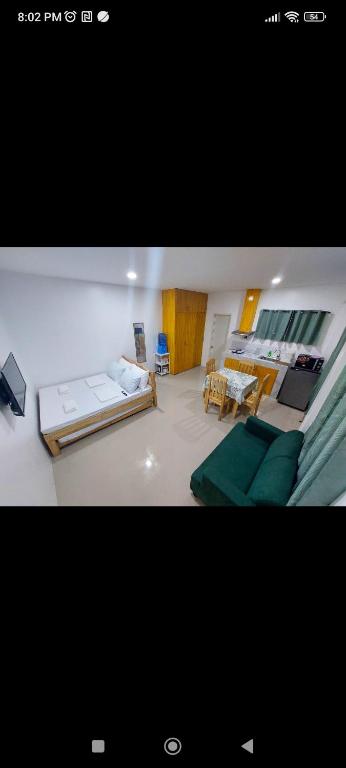 a living room with two beds and a table at Kylitas transient house studio apartment 1st floor in Tagbilaran City