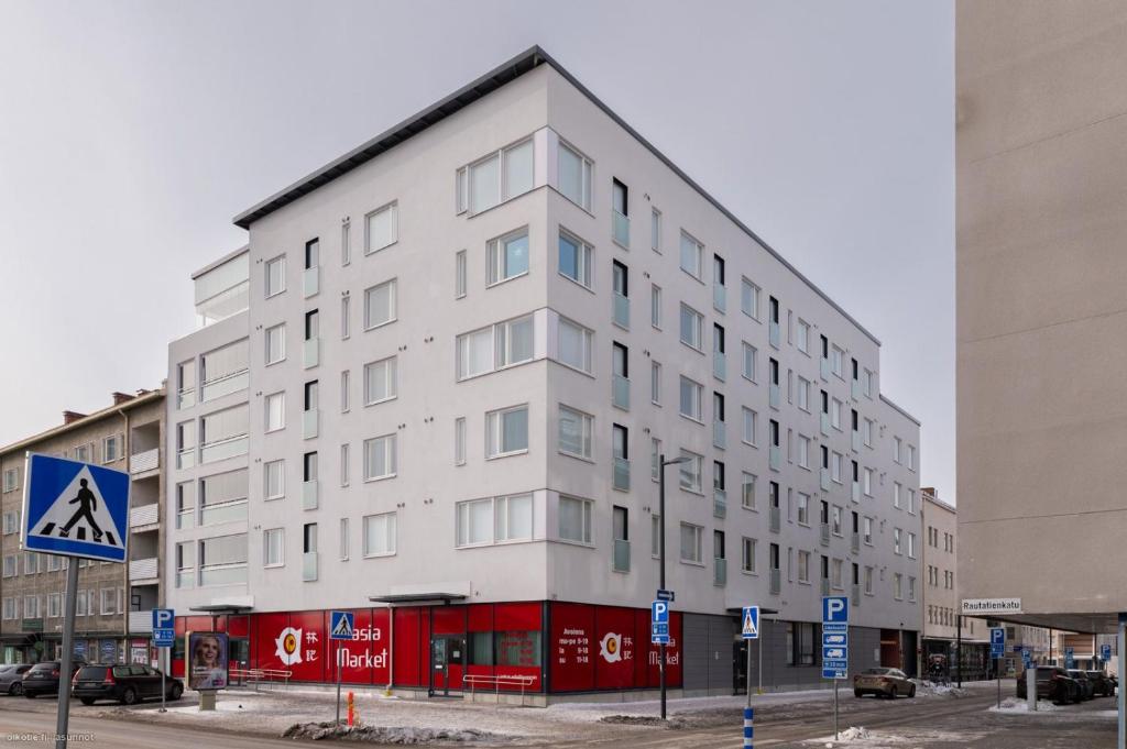 a white building on the corner of a street at Studio Apartment Station in Oulu