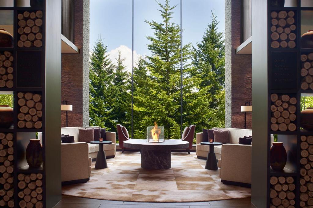 a lobby with a table and chairs and trees at Higashiyama Niseko Village, a Ritz-Carlton Reserve in Niseko