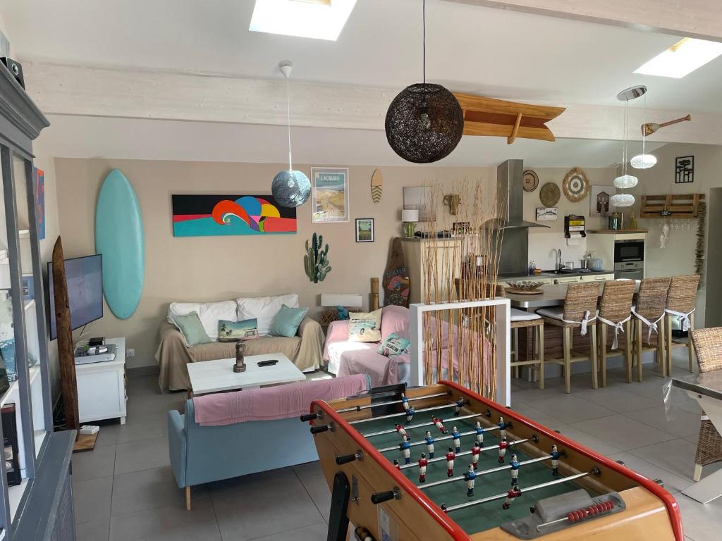 een woonkamer met een tafeltennistafel. bij "Les 2 Pins" Villas 4 chambres 10-12 couchages in Lacanau