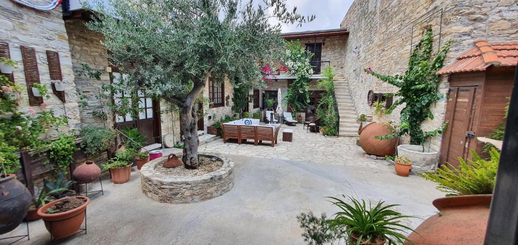 a courtyard with a table and a tree in it at Bougainvillea House Lefkara in Pano Lefkara