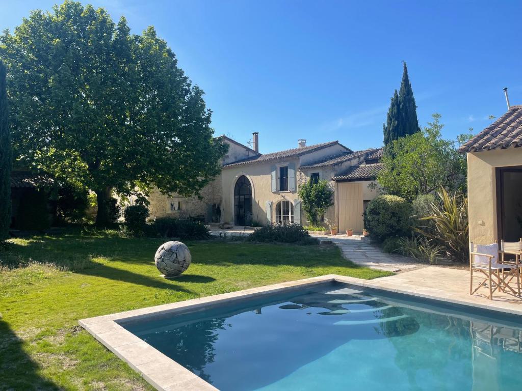 a swimming pool in the yard of a house at MAS MILLÉSIME - Chambre double - petit déjeuner - piscine - Mas du XVIIIème siècle proche Saint-Rémy-de-Provence in Mas blanc des Alpilles