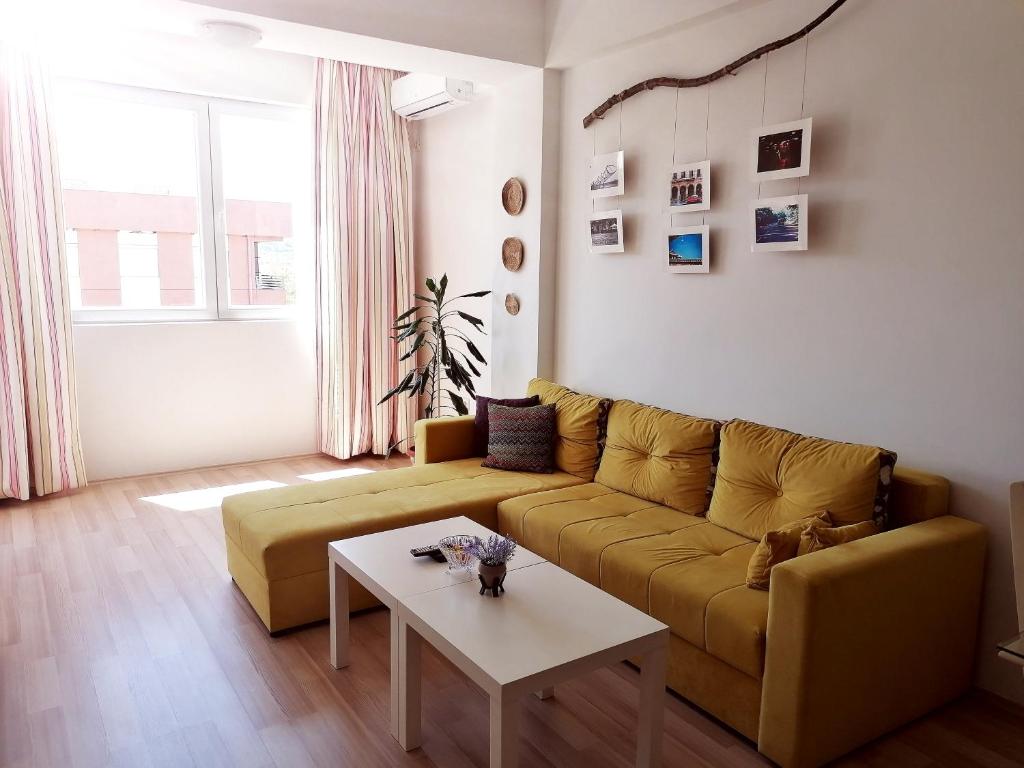 un soggiorno con divano giallo e tavolo di Tanja's Apartment a Štip