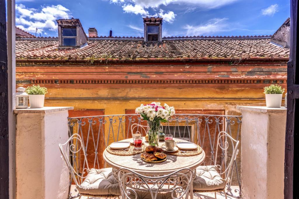 a table with a vase of flowers on a balcony at Maison Babuino in Rome