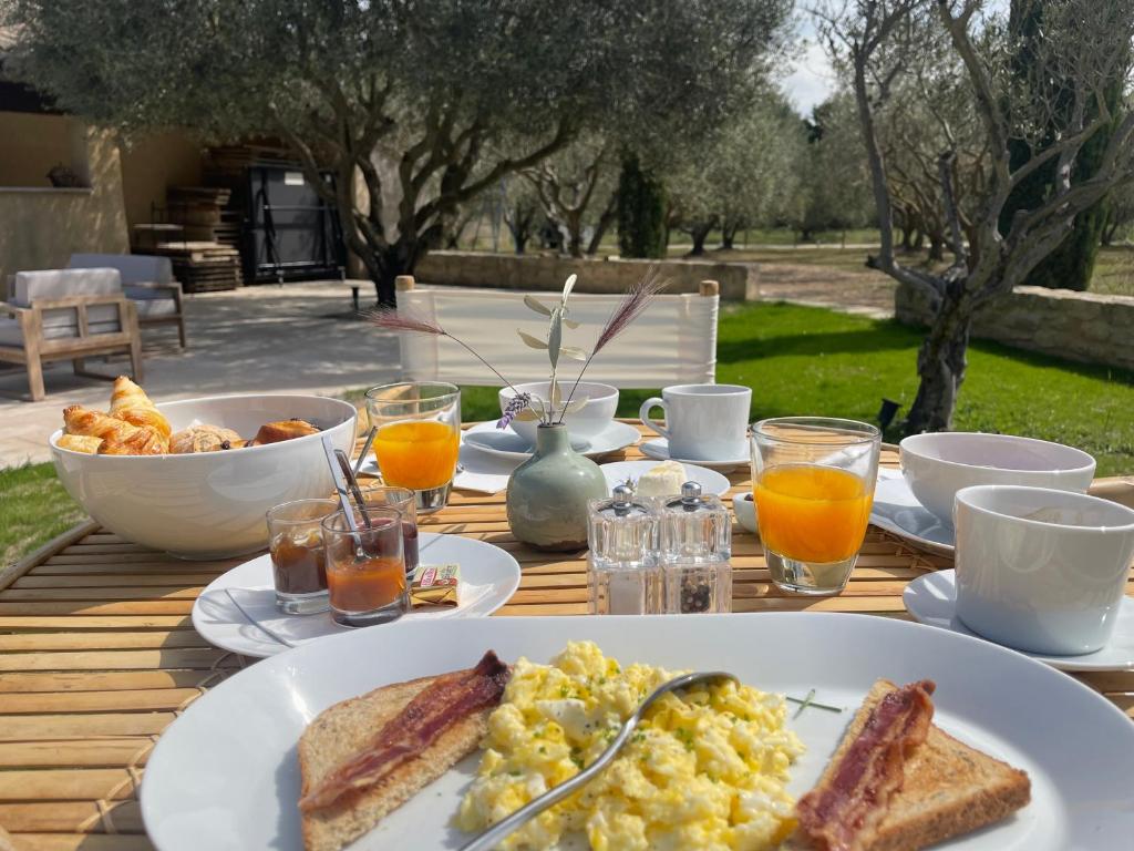 a breakfast table with eggs and toast and orange juice at MAS MILLÉSIME - Chambre double - petit déjeuner - piscine - Mas du XVIIIème siècle proche Saint-Rémy-de-Provence in Mas blanc des Alpilles