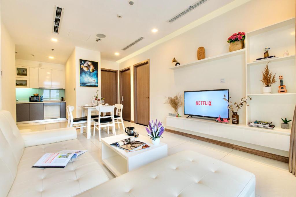 a living room with a white couch and a tv at MOTT HAVEN APART - Vinhomes Central Park, Landmark 81 Area & Ice Rink in Ho Chi Minh City