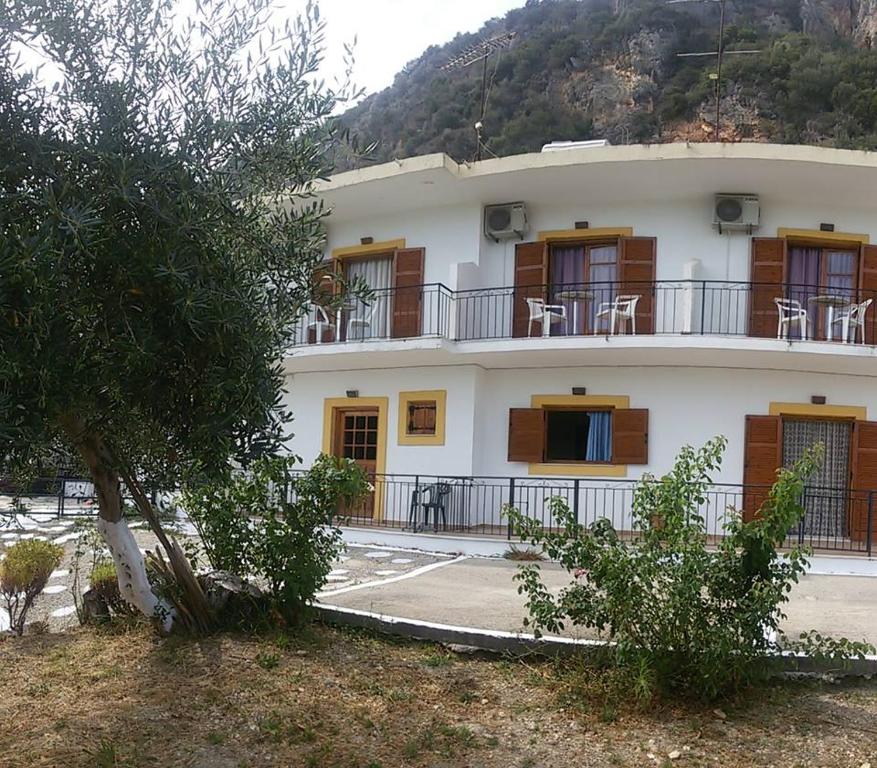 ein großes weißes Gebäude mit Fenstern und einem Balkon in der Unterkunft LITHERI-Studios&Apartment in Paleokastritsa