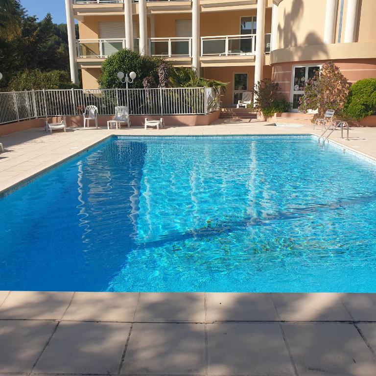 une grande piscine bleue devant un immeuble dans l'établissement Luxurious sea view apartment Cannes Vieux Cannet, au Cannet