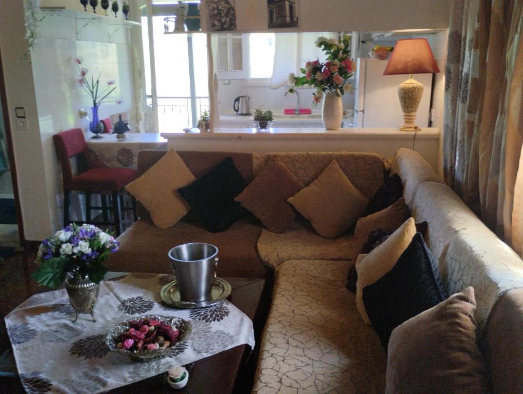uma sala de estar com um sofá castanho e uma mesa em Corfu Airport Flat em Corfu Town
