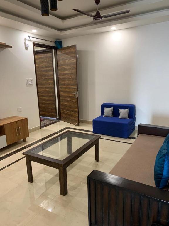 sala de estar con mesa de centro y sofá azul en Nature's Blessing Rishikesh 1BHK Studio, en Rishīkesh