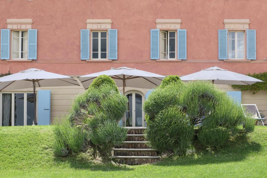 um edifício com guarda-sóis e escadas em frente em Fontelunga Hotel & Villas em Pozzo