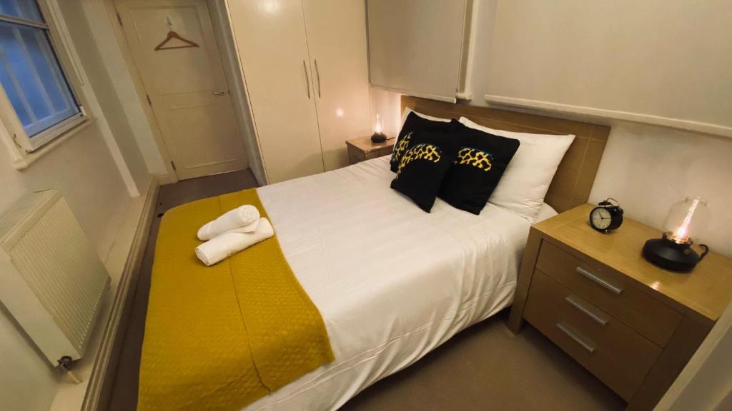 una piccola camera da letto con un letto e asciugamani di Shoreditch & Liverpool Steet Room A a Londra